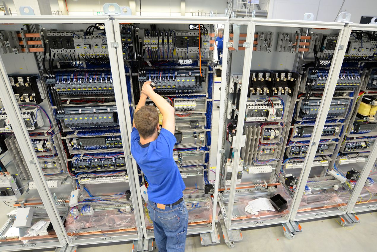 Uebersicht ueber mehrere Schaltschraenke mit eingebauten Hutschienen Switches in einer industriellen Fertigungsanlage